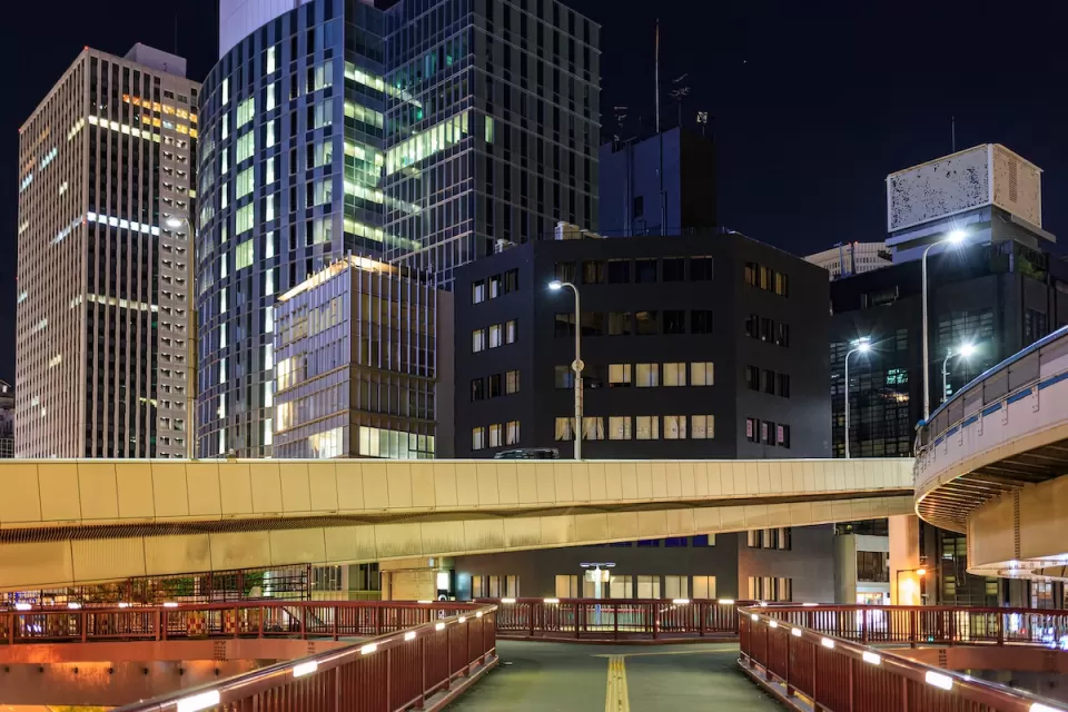 Vacant pedestrian overpass and skyscrapers in downtown financial district at night.